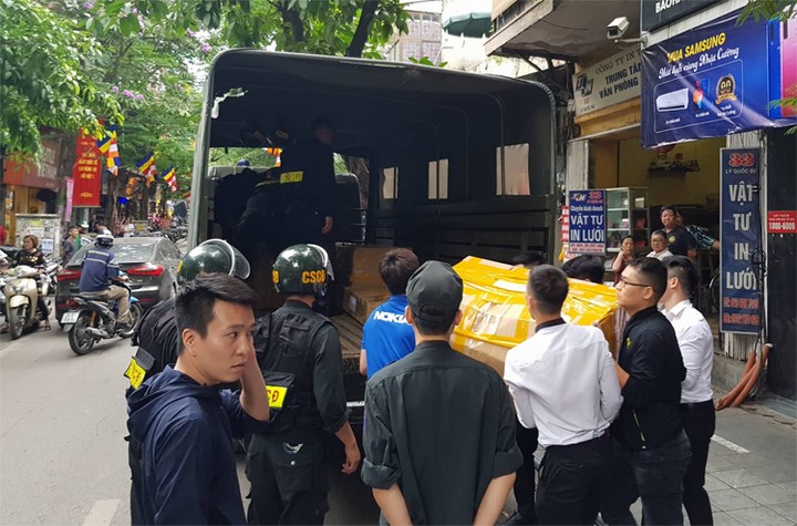 Gần 20 thùng các-tông được cảnh sát đưa từ cửa hàng trên phố Lý Quốc Sư lên chiếc xe tải thứ nhất. Ảnh: Tất Định Gần 20 thùng các-tông được cảnh sát đưa từ cửa hàng trên phố Lý Quốc Sư lên chiếc xe tải thứ nhất. Ảnh: Tất Định
